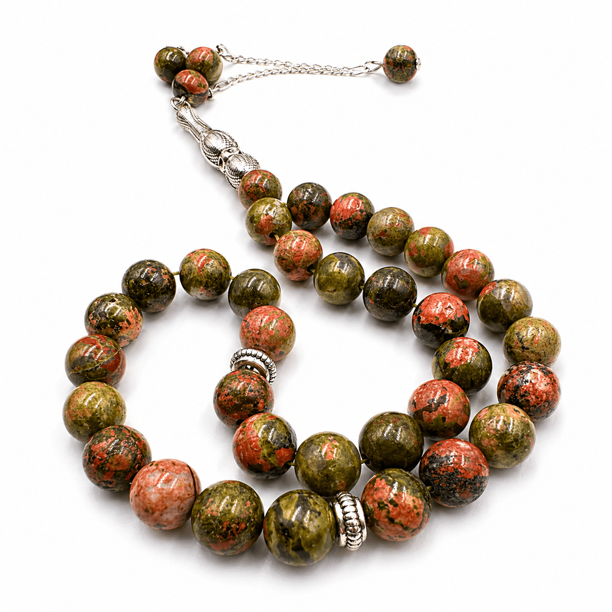 Bloodstone tasbeeh, the tassel coiled beside the strand — bloodstone for courage