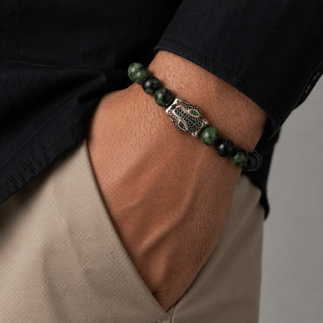 Crystal Emerald bracelet, on the wrist against a neutral ground — emerald for wisdom