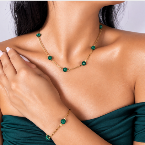 Malachite gold-plated silver chain necklace and bracelet set on white background