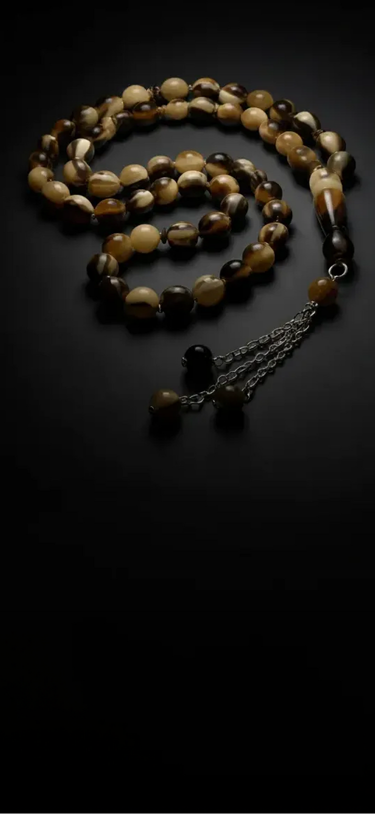Beaded necklace with a chain on a black background
