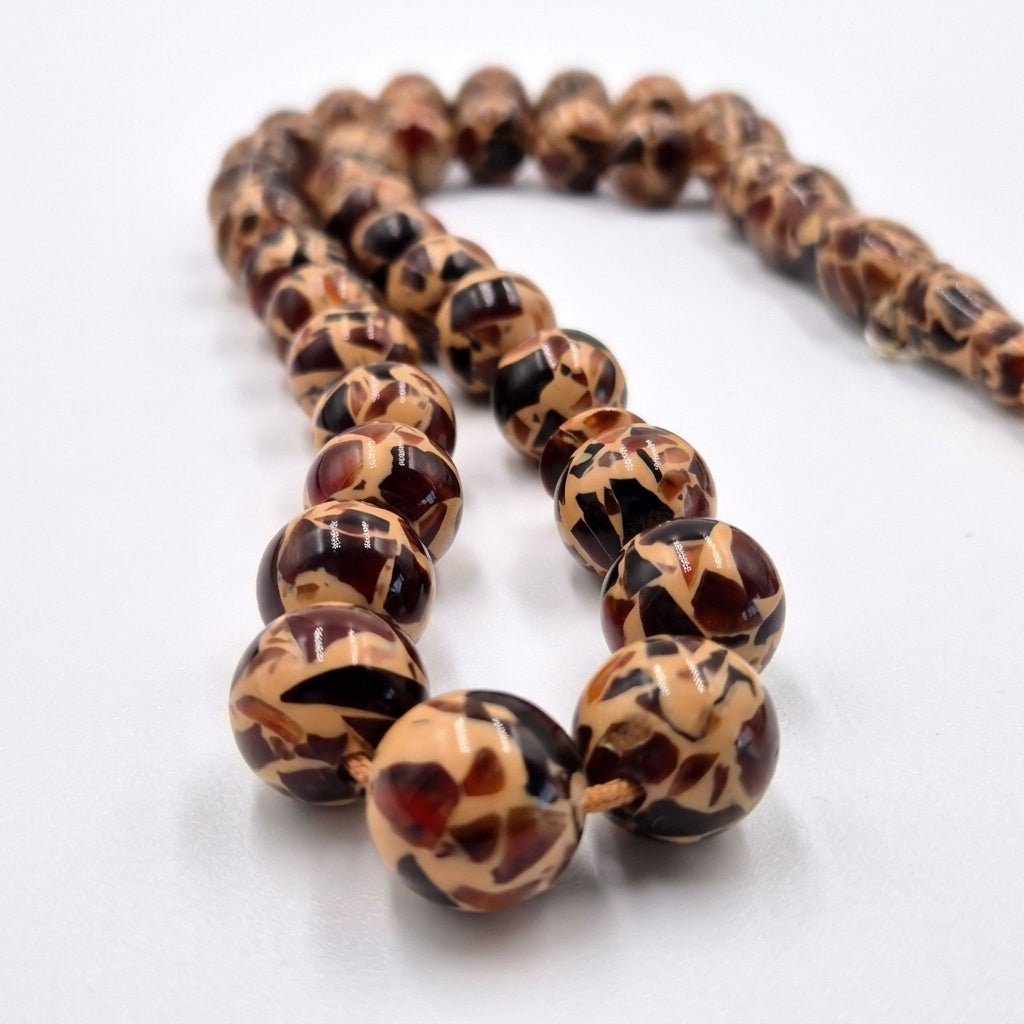 Tiger Skin Miski tasbeeh, the chain link and tassel join — amber toned beads