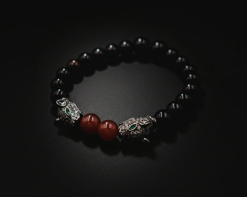 Agate bracelet with silver animal head charms and red beads on a white background