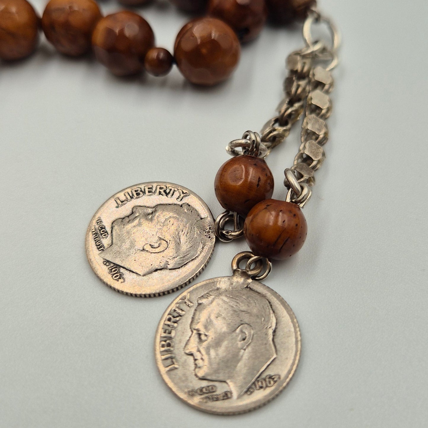 Carved from the resilient Narjil (Coconut) Shell, this tasbih combines organic warmth with metallic precision. Each bead is inlaid with striking Silver-Tone with Red and Blue Craftings.