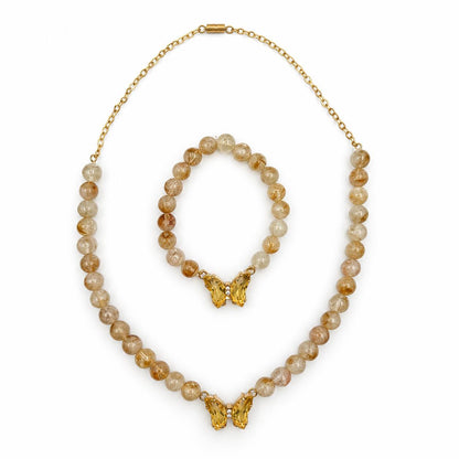 A gold-tone Citrine gemstone necklace and bracelet set with round amber-brown and cream beads, featuring butterfly-shaped gold pendants, displayed on a clean white background.