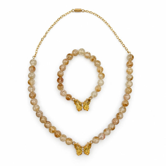 A gold-tone Citrine gemstone necklace and bracelet set with round amber-brown and cream beads, featuring butterfly-shaped gold pendants, displayed on a clean white background.