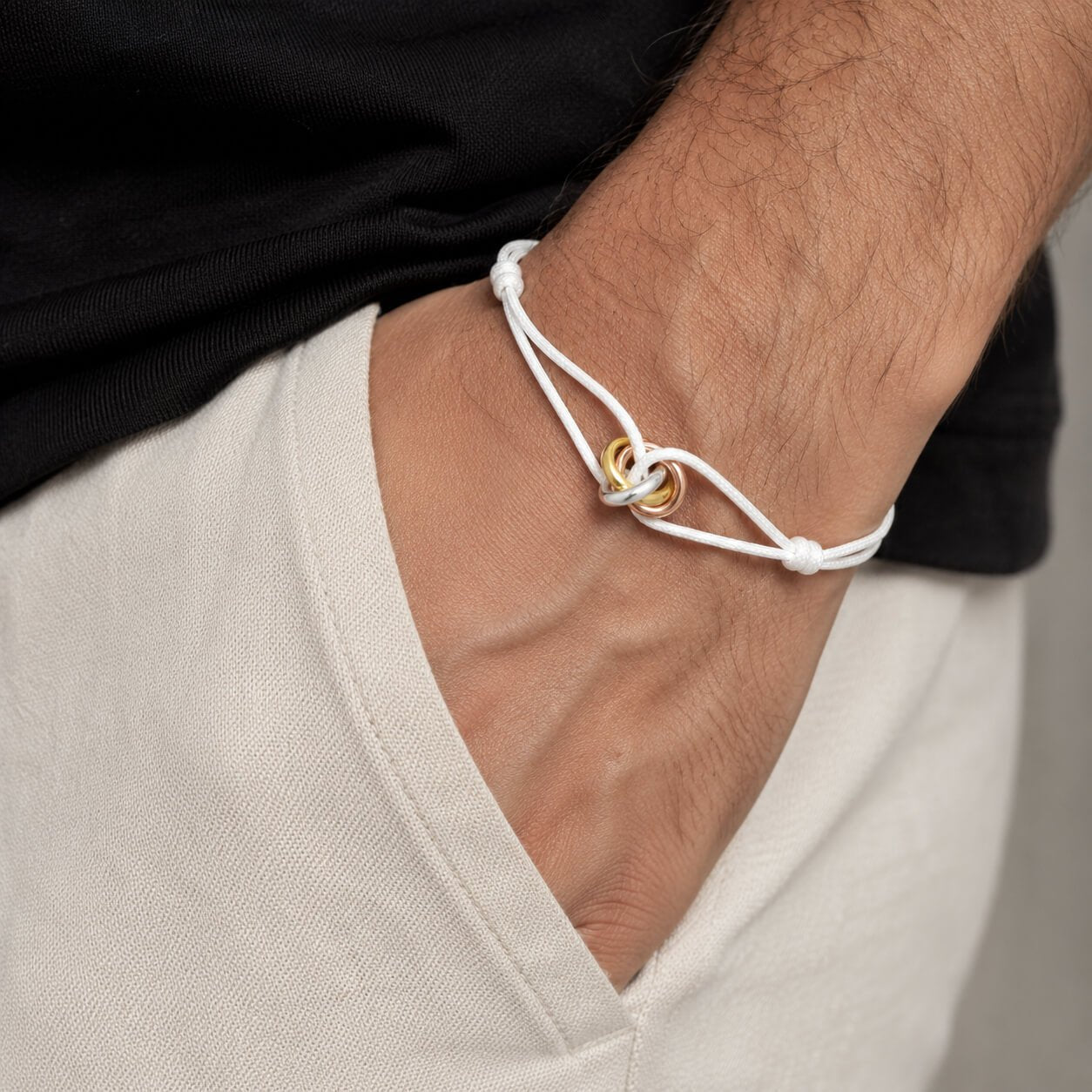 Trilogy Three-Ring adjustable cord bracelet, on the wrist against a neutral ground — everyday bracelet Dubai