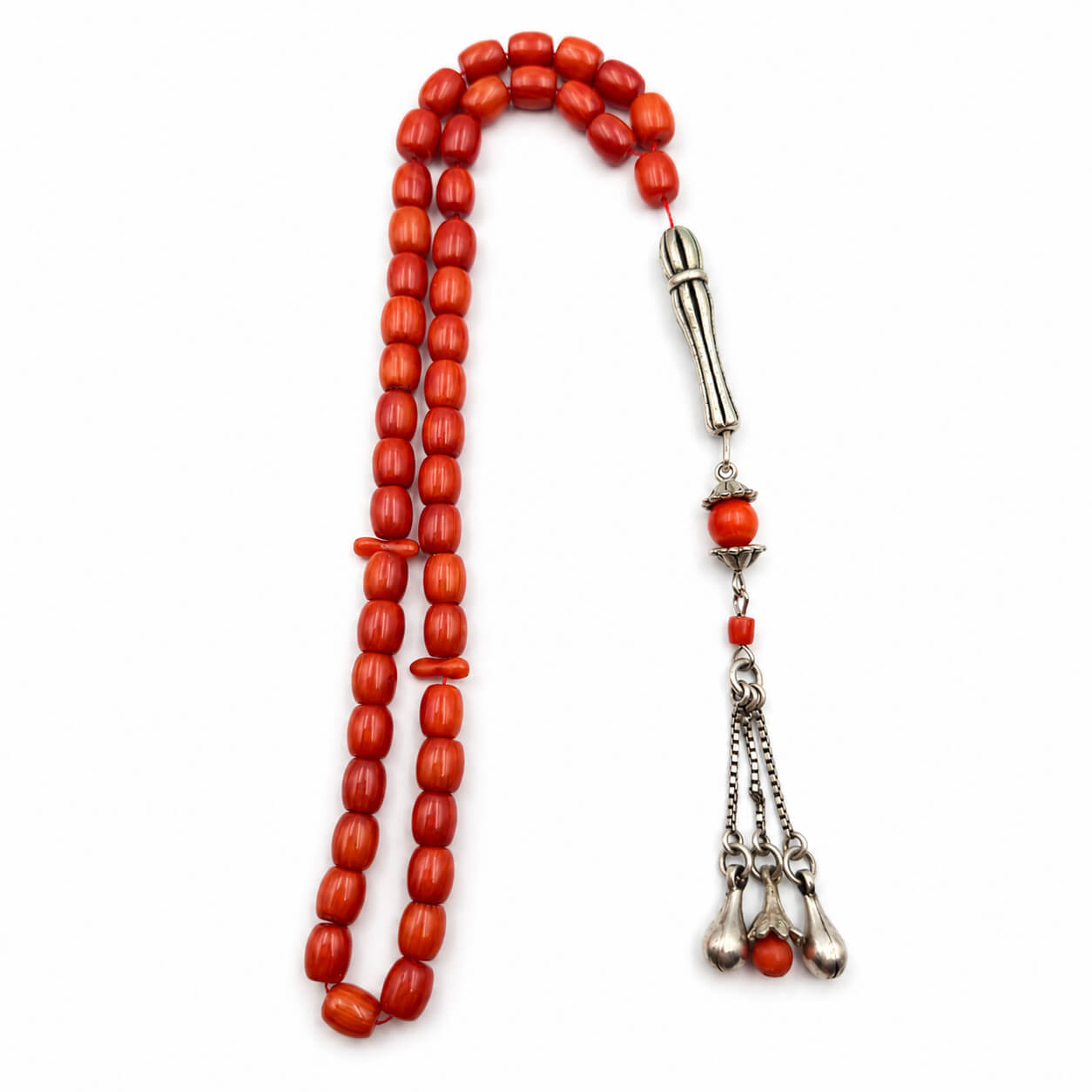Tasbih beads made of polished red coral beads and silver-toned metal elements.  Dubai coral