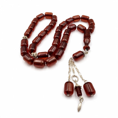 Ghazal Blood-Tone Miski misbaha, the tassel against the final bead — amber toned beads