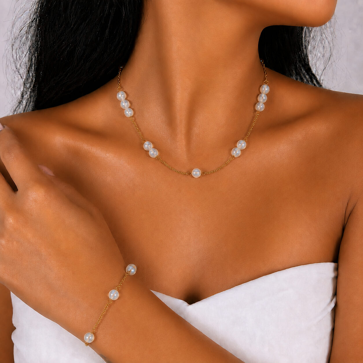 Moonstone gold-plated silver chain necklace and bracelet set, worn on the wrist — moonstone for clarity