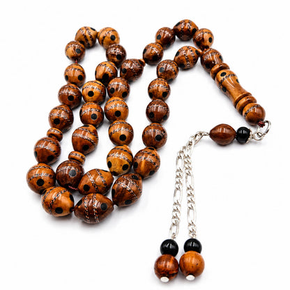 Copper and Yusur Crafted Narjil misbaha, the tassel coiled beside the strand — rare yeser wood beads
