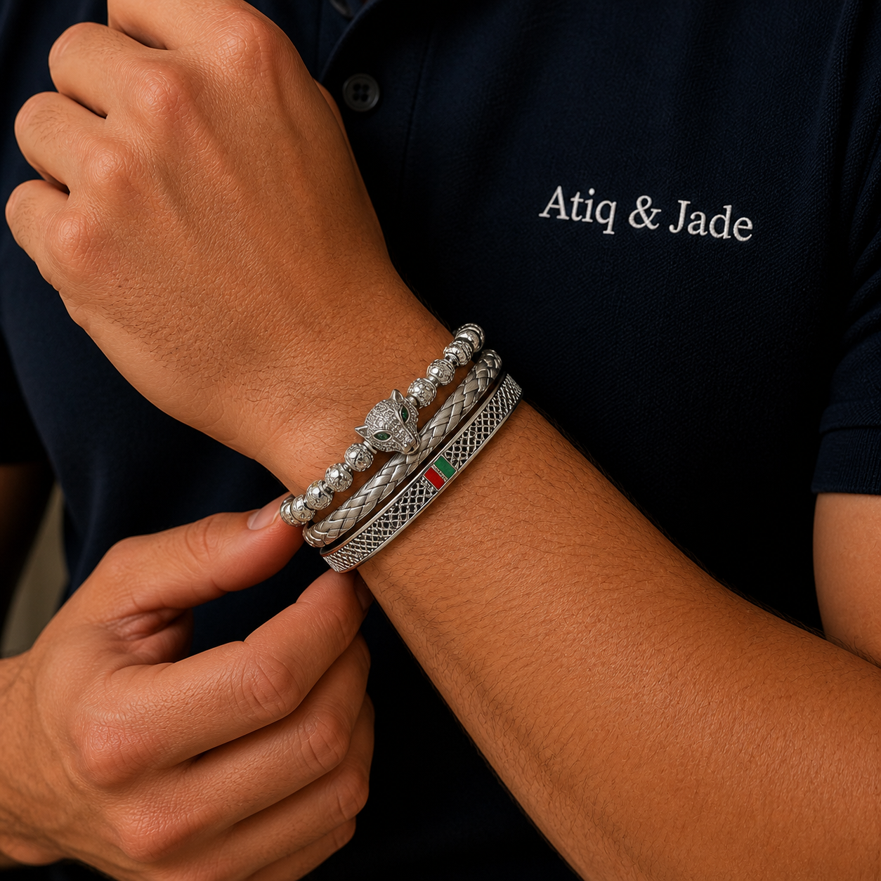 Person wearing multiple silver bracelets on a wrist with 'Atiq & Jade' branding in the background.